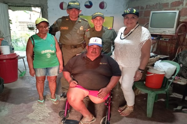 Policías entregando silla de ruedas