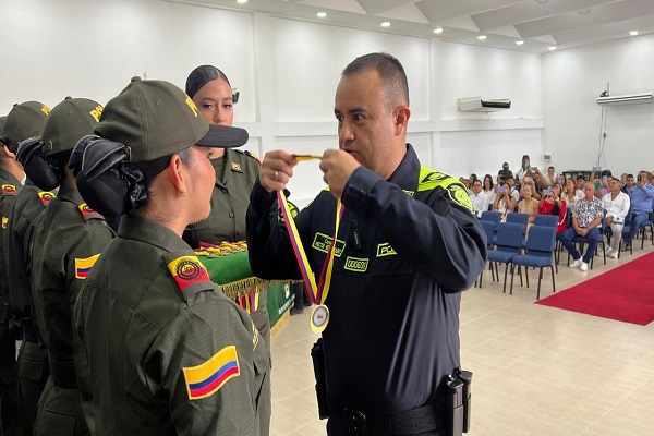 El señor coronel Betancourt impone una medalla a un Auxiliar de Policía