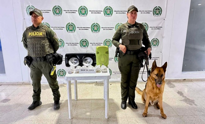 Dos funcionarios policiales un canino, una mesa con incautación 