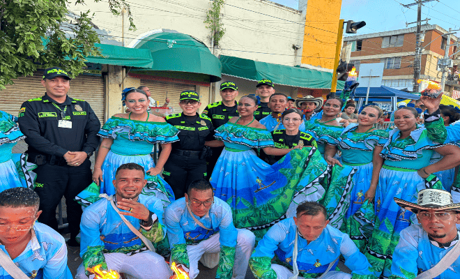 cuatro uniformados con un grupo de participantes de comparsas feria nacional de la ganader&iacute;a 