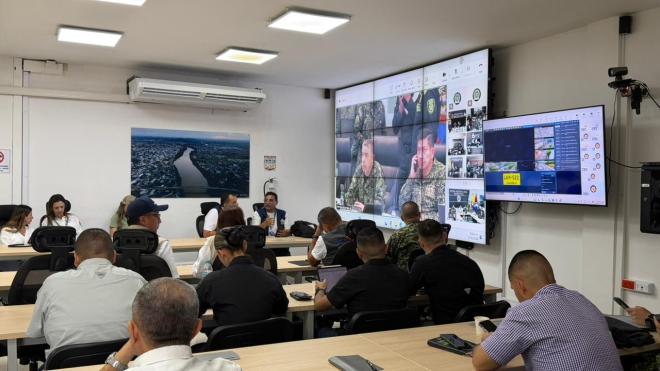 un grupo de doce personas en  una sala  monitoreando el proceso electoral
