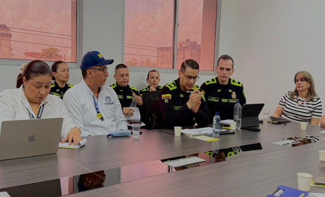 cinco señores uniformados de la Policía nacional en reunión con un personal de la Gobernación  de Montería