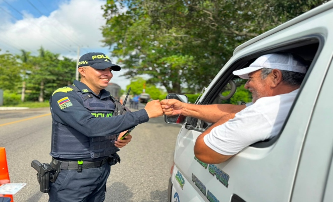 un uniformado de la Policía Nacional saludando a un ciudadano en la vía de el municipio de Cereté 