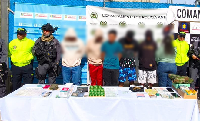 6 capturados por el delito de tráfico de estupefacientes en Antioquia, policias y ejercito custodiandolos, elementos incautados sobre una mesa.