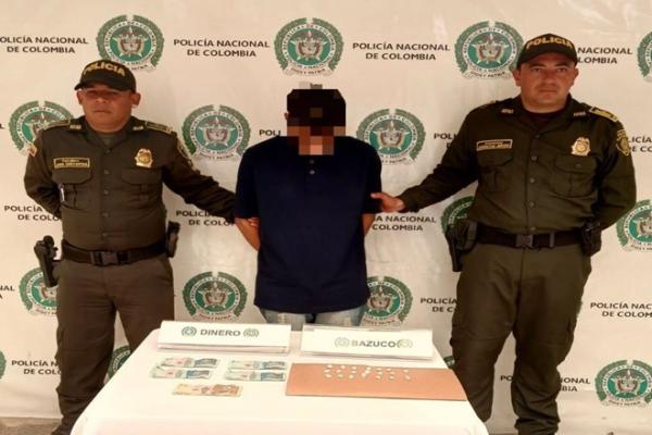 Tres personas, dos polic&iacute;as y un capturado en el medio 
