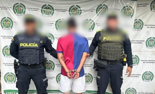 Dos funcionarios policiales junto a un ciudadano capturado 