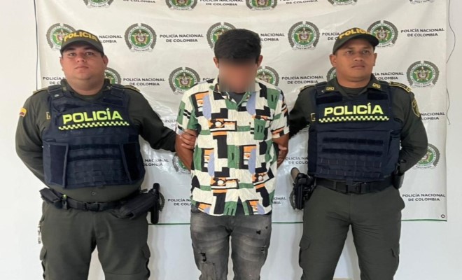 Un capturado custodiado por dos funcionarios de policía  