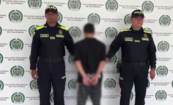 Dos policías con uniforme azul custodian a un capturado en operativo en el oriente