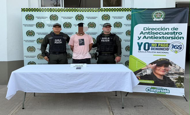 Una persona de sexo masculino capturada por el delito de extorsión, acompañado de dos uniformados de la Policía Nacional brindando seguridad.