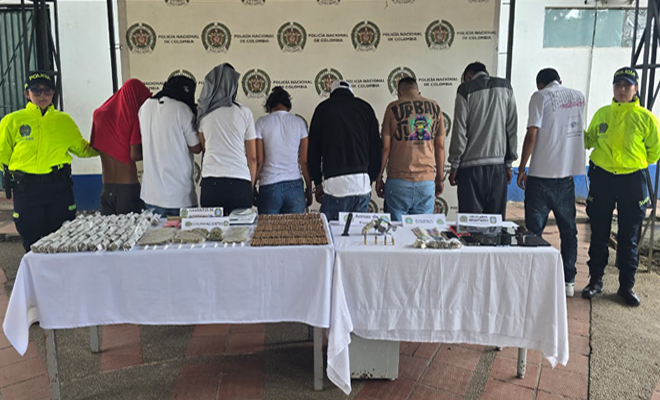 dos polic&iacute;as, ocho personas capturadas y una mesa con estupefacientes y un arma de fuego