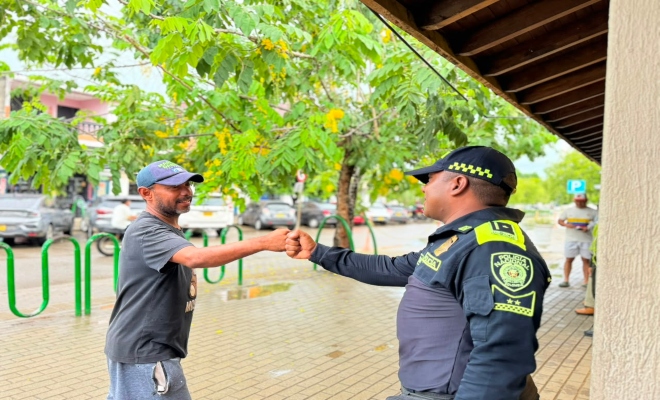 un uniformado de la policía nacional dándole la mano a un ciudadano 