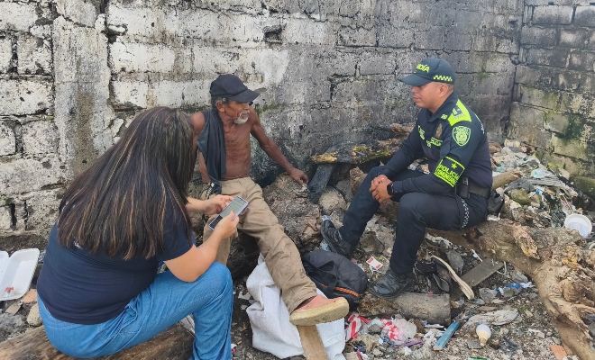 Funcionario policial y de la alcaldía conversando con ciudadano en condición de habitante de calle 