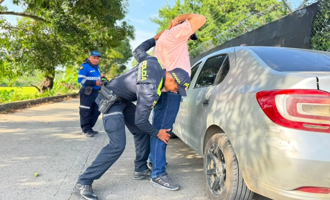 Funcionario policial realizando un registro a persona a un ciudadano en compañía de funcionario de transito municipal
