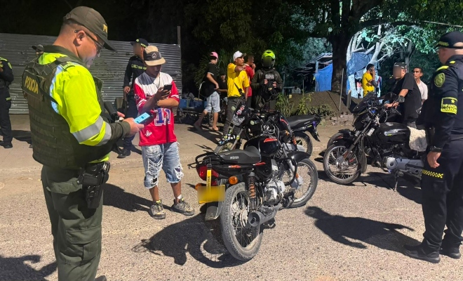 Funcionario policial de la dirección de transito y transporte realizando consulta de antecedentes a una motocicleta