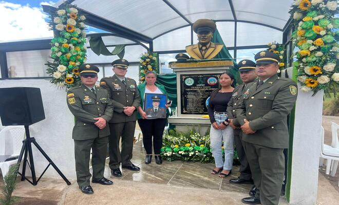 Cuatro policías con dos mujeres frente ha placa conmemorativa 