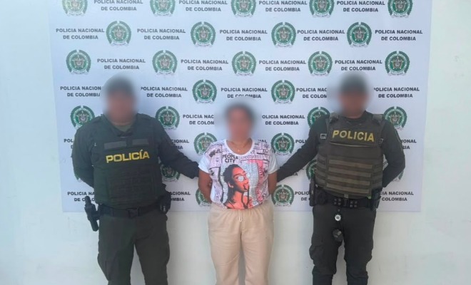 Dos policías agarrando a una mujer del brazo
