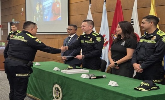 Dos uniformados saludando al entregar un diploma