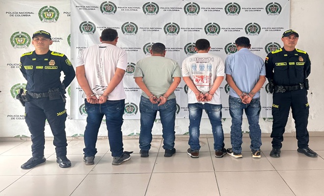 Dos polic&iacute;as custodiando cuatro capturados