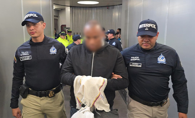 Alias 'Gustavo' es custodiado por los pasillos del Aeropuerto El Dorado, por funcionarios de INTERPOL , despu&eacute;s de llegar extraditado de Espa&ntilde;a.