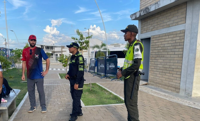 Dos funcionarios policiales brindando recomendaciones a un ciudadano en la villa olímpica de Vallejo
