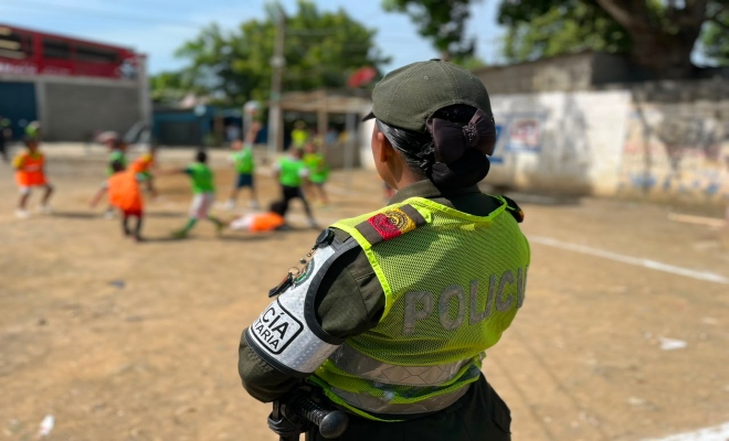 una funcionaria de la Policía nacional prestando seguridad en la cancha del barrio sucre