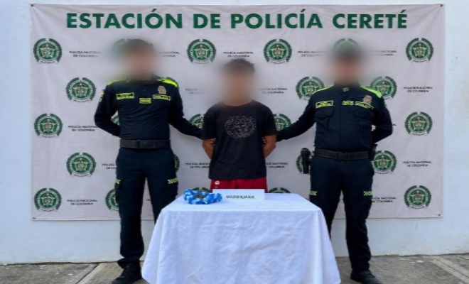 Dos policía custodiando una persona capturada por el delito de de Fabricación, tráfico o porte de estupefacientes