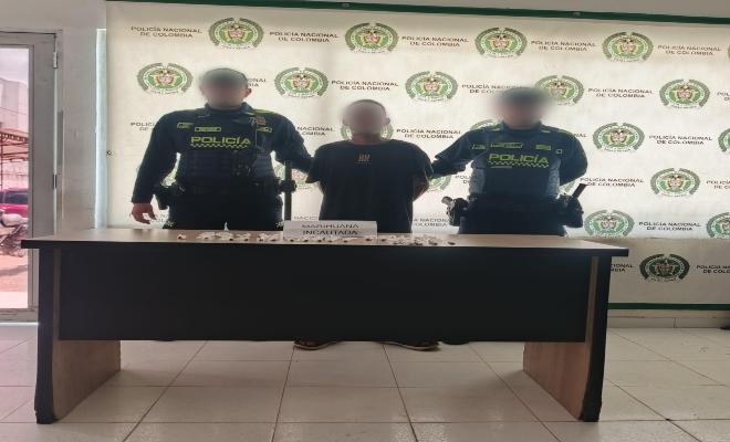 Dos uniformados custodiando una persona por el delito Tráfico, fabricación o porte de estupefacientes