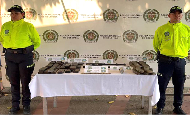 Se observa dos policía de la SIJIN una mesa y sobre esta 02 receptores con sus respectivos cañones para armas de fuego tipo fusil, 47 proveedores , 63 cartuchos de diferente calibre y una granada de aturdimiento