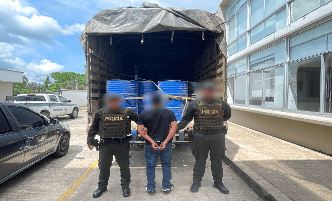 Un camión, y frente a él dos policías junto a un hombre señalado de transportar sustancias ilegales