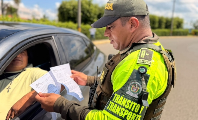 Funcionario policial de transito realizando verificación de documentos a un ciudadano dentro de un vehículo