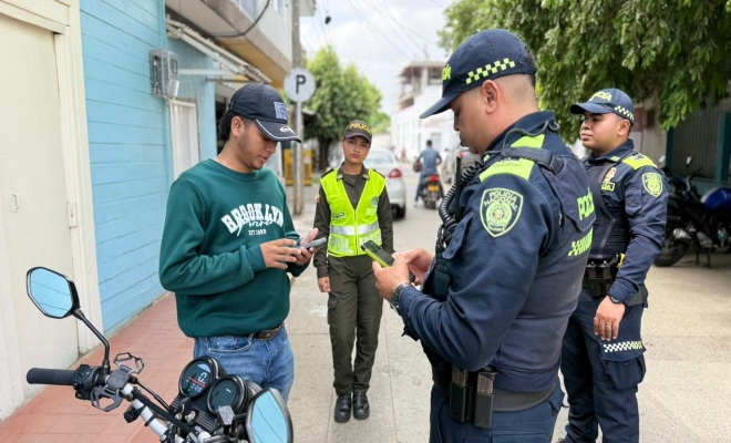 dos uniformados realizando registro  vehículo y personas  en el sector bancario del municipio de Cereté 