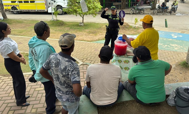 Una funcionaria policial dialogando con seis ciudadanos en vía publica
