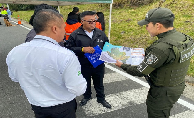 un policía dando instrucción y sensibilización a conductores y  viajeros sobre las rutas seguras