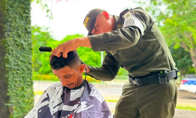 Auxiliar de policía cortando cabello de un ciudadano 