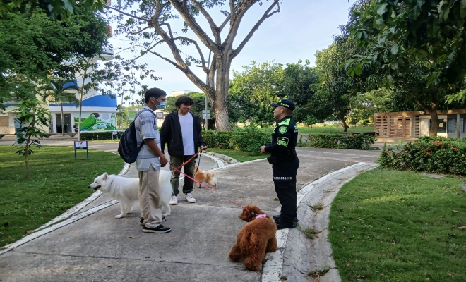 un polic&iacute;a brindando recomendaciones de seguridad a dos ciudadanos 