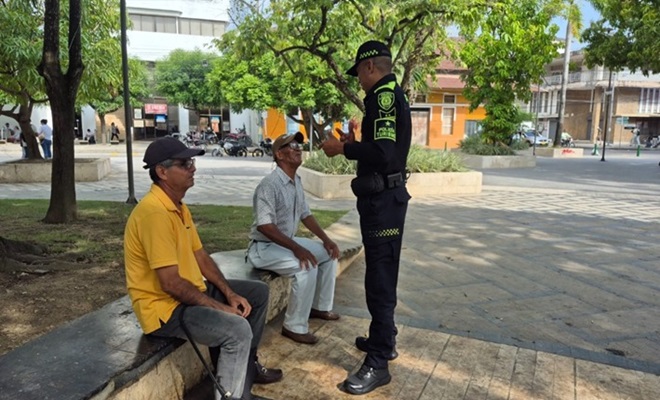 Un funcionario policial dialogando con dos ciudadanos 