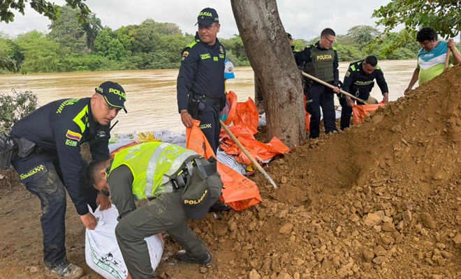 Polic&iacute;as cargando sacos con arena