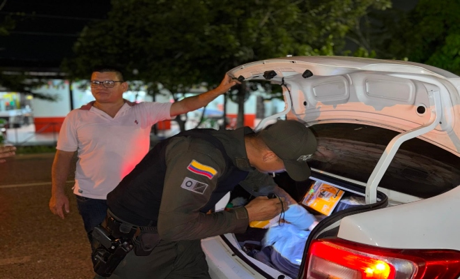 Funcionarios policiales realizando registro a vehículo y consulta de antecedentes a un ciudadano