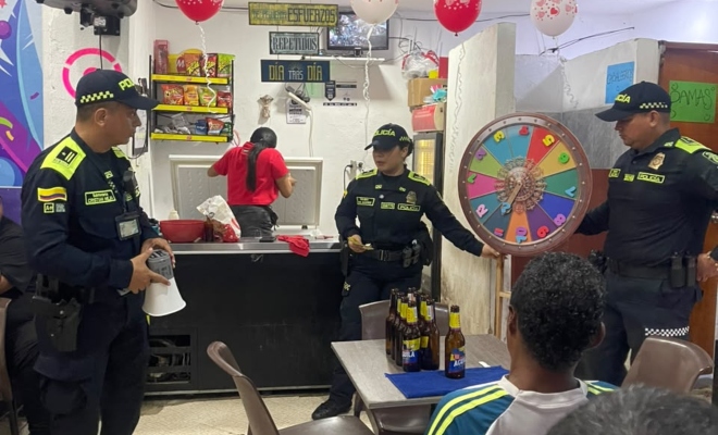 Tres funcionarios policiales con ciudadanos en actividad dirigidas a comerciantes, visitantes del mercado del sur