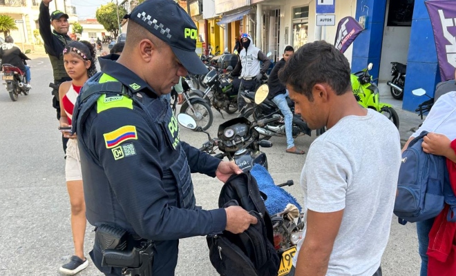 Dos funcionarios policiales realizando registro a un ciudadano en vía publica 