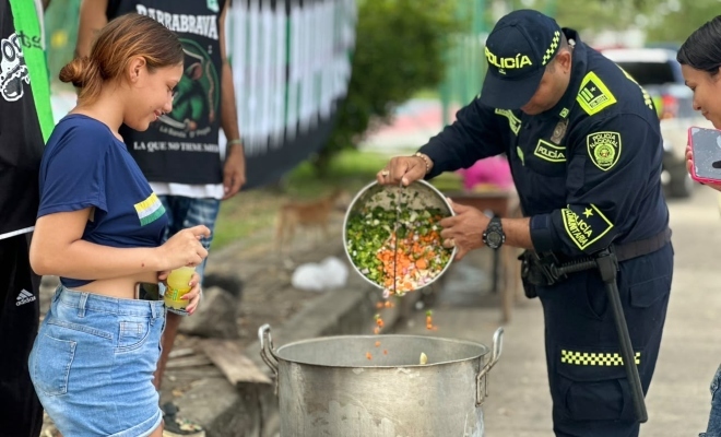 Funcionario policial junto a una ciudadana en actividad de olla comunitaria 