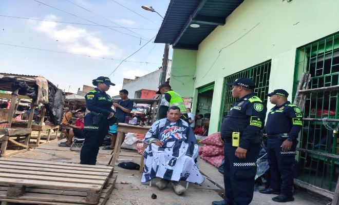 cuatro uniformados en labores de prevención el el mercadito del sur con un ciudadano 