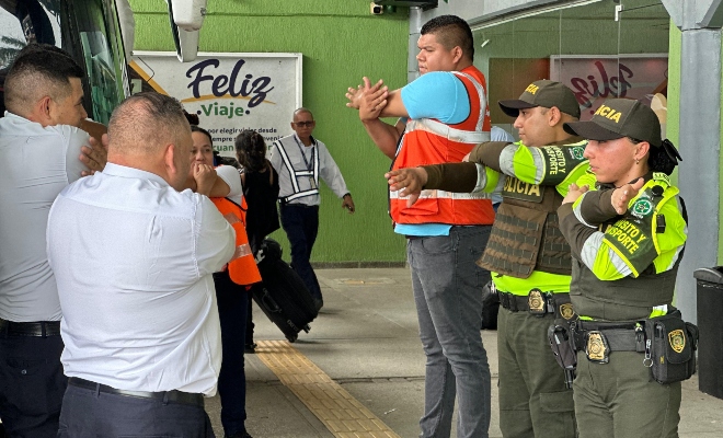 Dos funcionarios policiales de transito y transporte en pausa activa con un grupo de conductores 