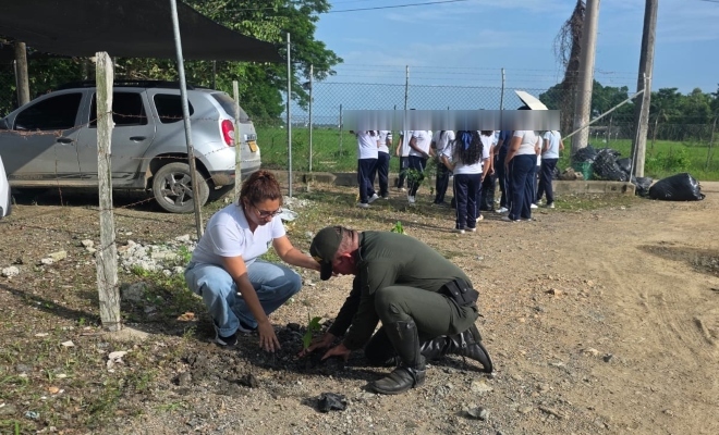 Funcionario policial realizando actividad de limpieza y recuperación de espacios junto a una ciudadana