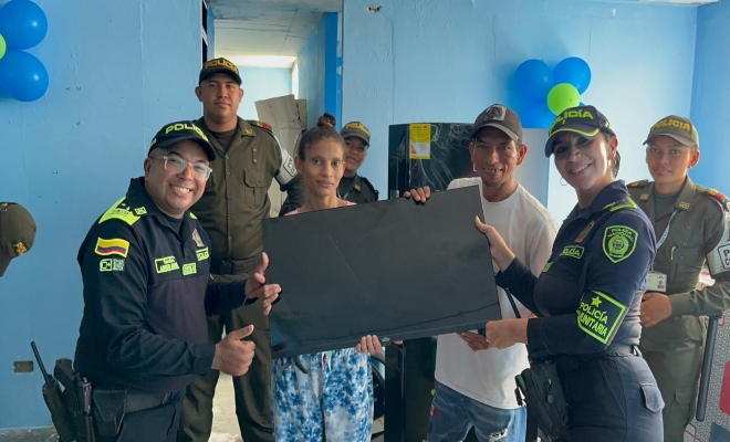 cincos uniformados de la policía entregan  ayudas a una familia en montería