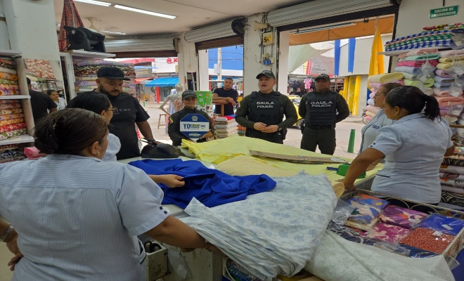 tres policías realizando charlas a ciudadanos  dentro de un local 