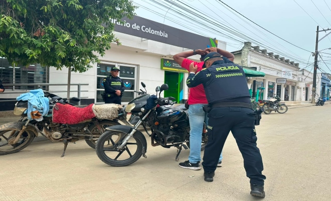 un uniformado de la policía nacional realizando registro a personas