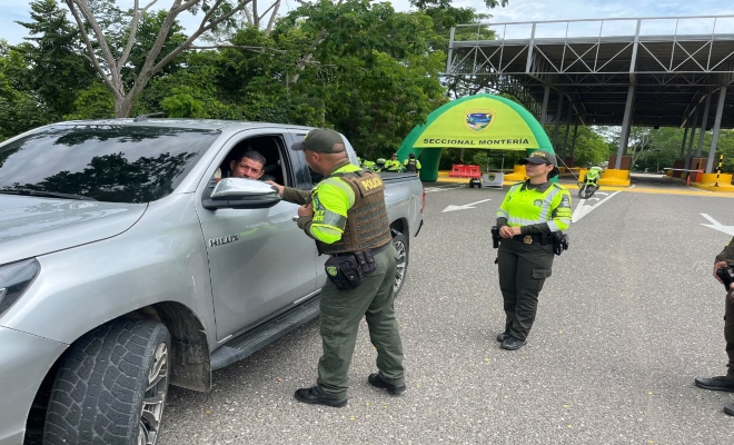 un policía saludando a la comunidad y un policía prestando seguridad 