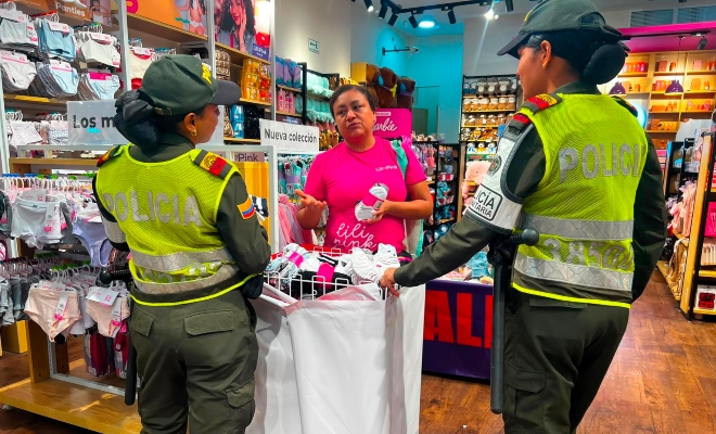 Dos auxiliares de policía brindando recomendaciones de a una ciudadana