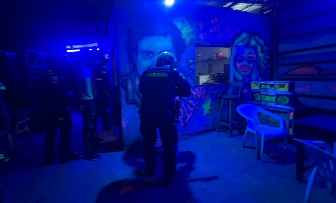 Grupo de funcionarios policiales realizando registro a persona en establecimientos públicos a orillas del rio 